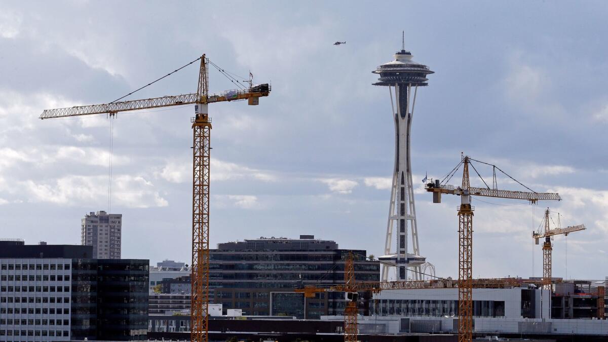 At 605 feet, the Space Needle towers over construction cranes in Seattle.