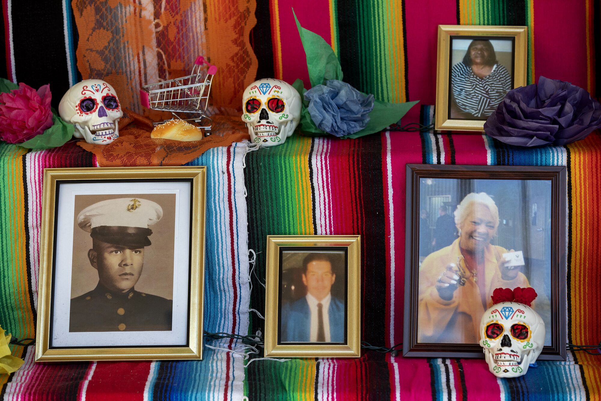 Victims' photos are set among brightly pained skulls in a community altar.