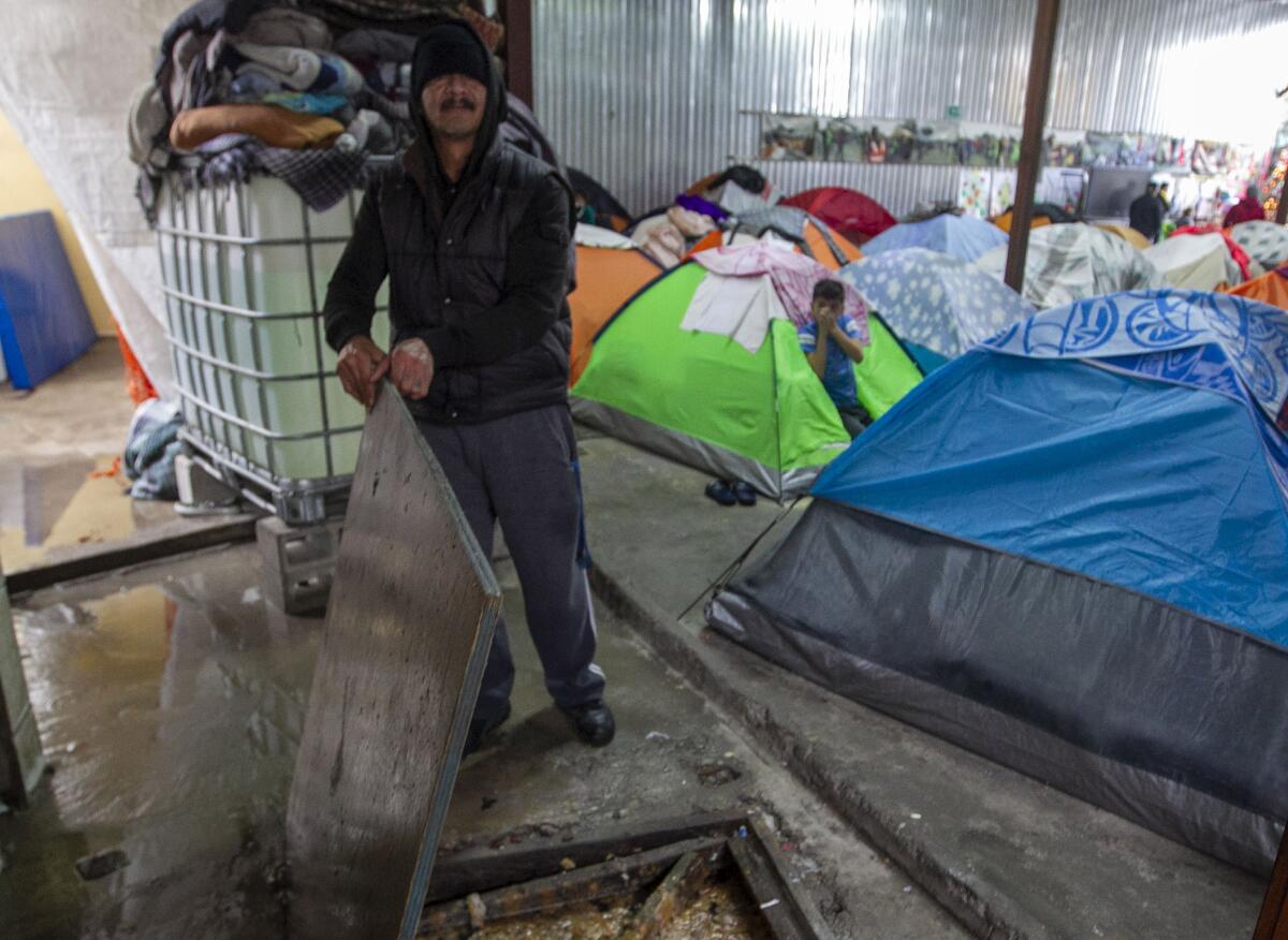 An employee at the Juventud 2000 shelter in the Zona Norte neighborhood in Tijuana showed where raw sewage flowed in to the shelter during the rains on Monday, Dec. 23, 2019. The young man in the green tent holds his nose.