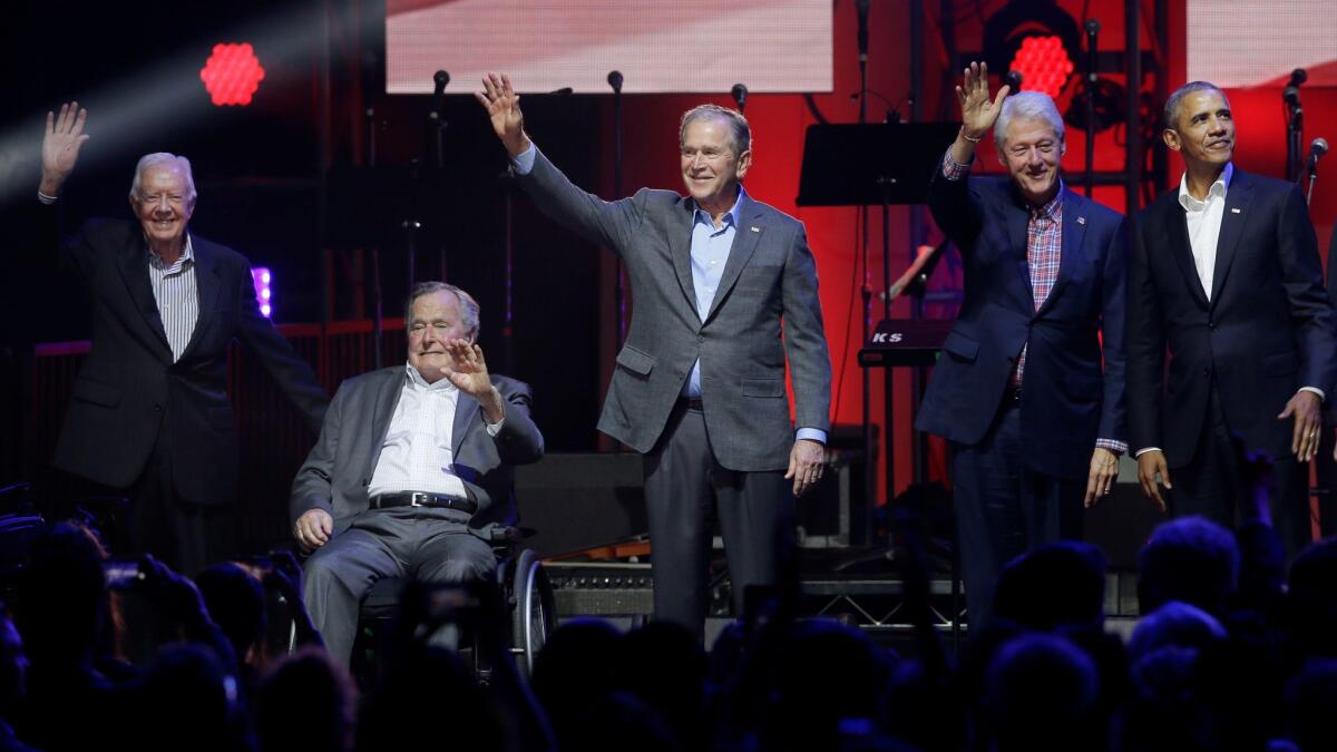 Former Presidents Jimmy Carter, left, George H.W. Bush, George W. Bush, Bill Clinton and Barack Obama acknowledge the crowd at the opening of a hurricane relief concert on Saturday in College Station, Texas.