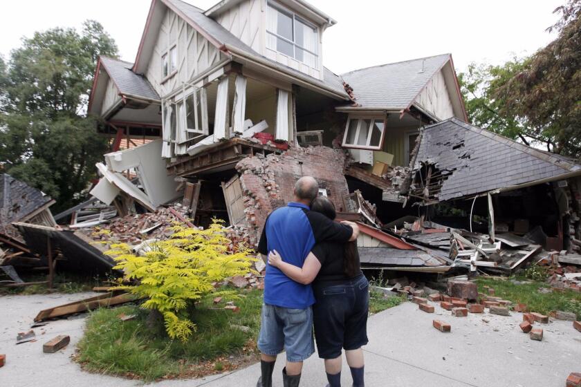 Murray and Kelly James look at their destroyed house in central Christchurch, New Zealand, Wednesday, Feb. 23, 2011. Tuesday's magnitude6.3 temblor collapsed buildings, caused extensive other damage and killed dozens of people in the city. (AP Photo/Mark Baker) @@*@@* Usable by LA and DC Only @@*@@*