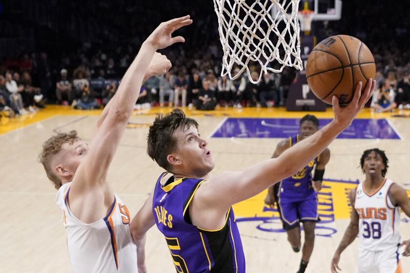 Los Angeles Lakers guard Austin Reaves, right, shoots as Phoenix Suns center Jock Landale defends during the first half of an NBA basketball game Friday, April 7, 2023, in Los Angeles. (AP Photo/Mark J. Terrill)