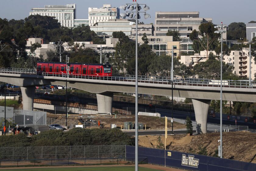 SAN DIEGO, CA - OCTOBER 14: A trolley on the MTS Mid-Coast Extension Blue Line heads away from the UC San Diego central campus stop toward UTC on Thursday, Oct. 14, 2021 in San Diego, CA. (K.C. Alfred / The San Diego Union-Tribune)