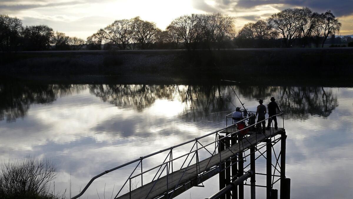 People fish along the Sacramento River in the San Joaquin-Sacramento Delta near Courtland, Calif.