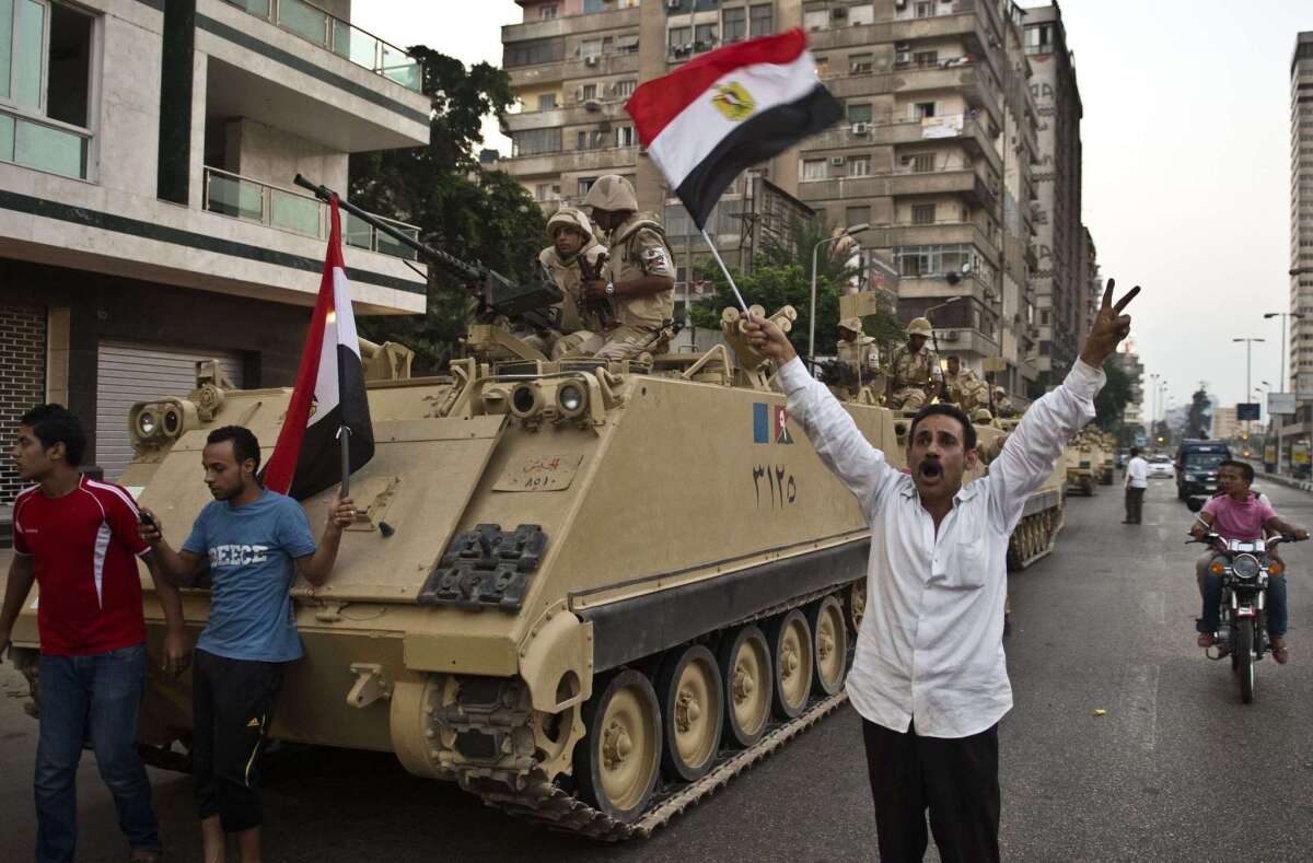 Egyptians cheer army tanks deployed on a street leading to Cairo University on July 3, 2013.