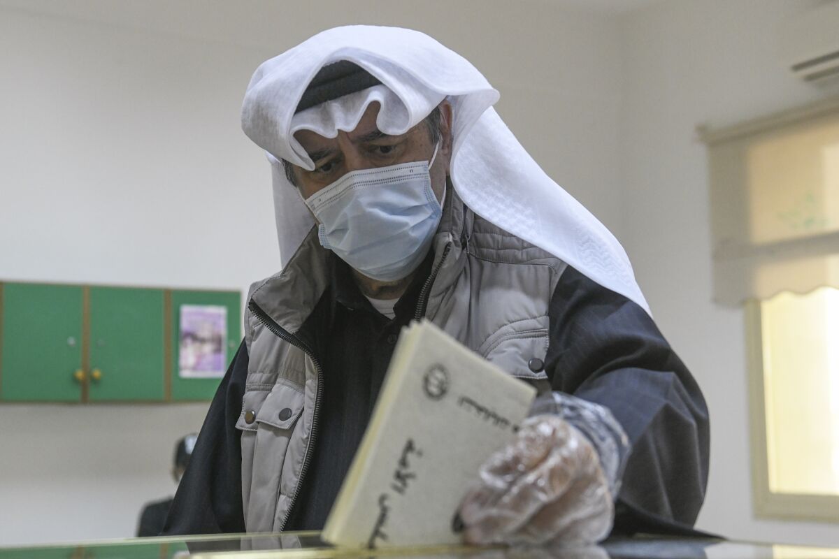 A man casts heis vote for parliamentary elections in the town of Hawally, Kuwait, Saturday, Dec. 5, 2020. (AP Photo/Jaber Abdulkhaleg)
