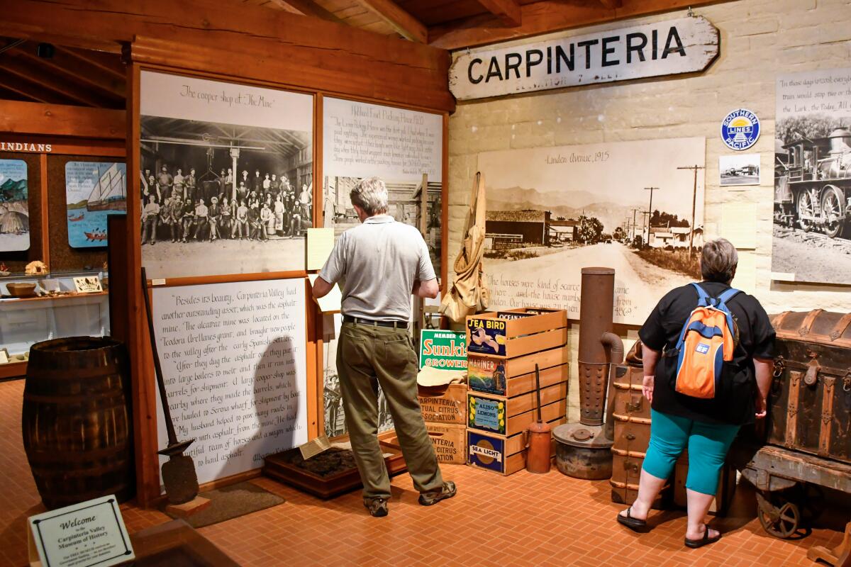 Two visitors browse the Carpinteriva Valley Museum of History.