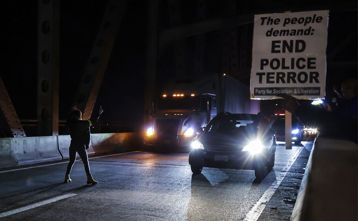 A demonstrator tries to stop traffic along the Interstate 95 bridge during a protest over the death of Tyre Nichols, Friday, Jan. 27, 2023, in Memphis, Tenn. Authorities released video footage Friday showing Nichols being beaten earlier this month by five Memphis police officers who held the Black motorist down and repeatedly struck him with their fists, boots and batons as he screamed for his mother. (Patrick Lantrip/Daily Memphian via AP)
