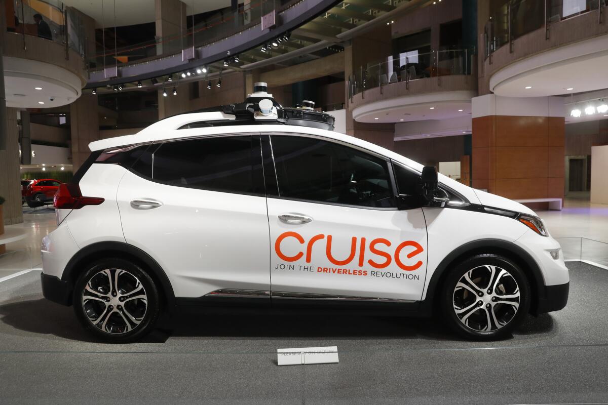 A Chevy Bolt with "Cruise" written on its side. Below it is the phrase "Join the Driverless Revolution."