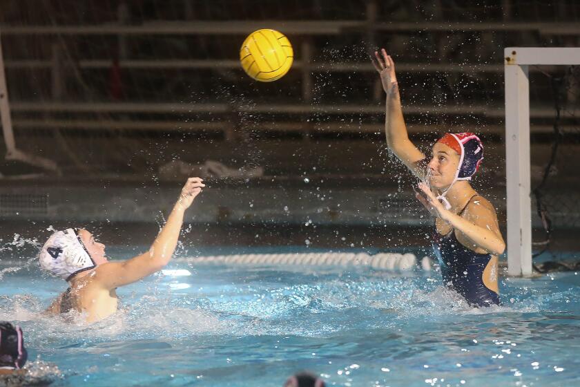 Newport Harbor's Morgan Netherton shoots high over Corona del Mar goalie Maya Avital for a goal during Battle of the Bay Surf League water polo match on Thursday.