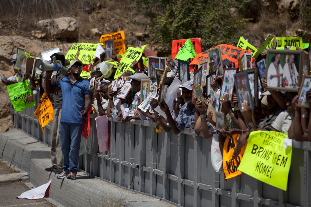Ethiopian Israelis hold up photographs of their relatives during a demonstration outside Prime Minister Benjamin Netanyahu's office in Jerusalem on Wednesday.