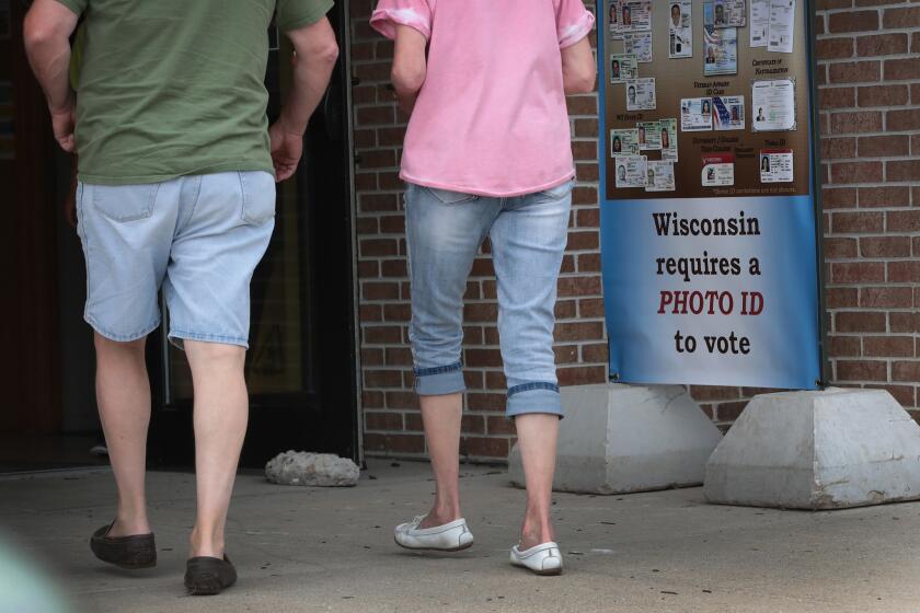 ELKHORN, WI - AUGUST 14: A sign outside of a polling place warns voters that they will need a photo ID to vote on August 14, 2018 in Elkhorn, Wisconsin. Wisconsin voters cast ballots in primary races today to pick challengers for Republican Governor Scott Walker, U. S. Senator Tammy Baldwin (D-WI) and to choose a replacement retiring Congressman Paul Ryan (R-WI) and other political races. (Photo by Scott Olson/Getty Images) ** OUTS - ELSENT, FPG, CM - OUTS * NM, PH, VA if sourced by CT, LA or MoD **