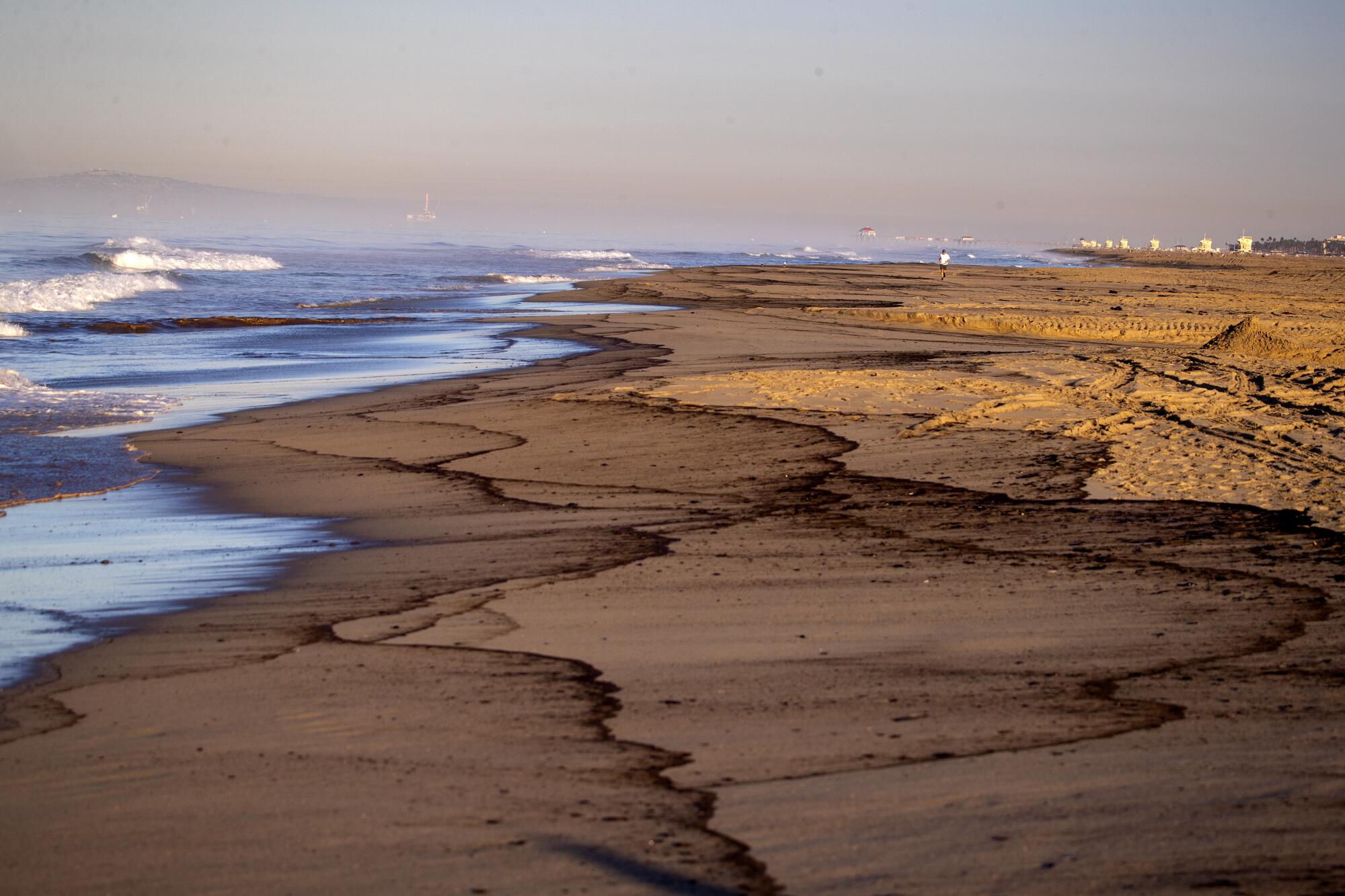 An oil slick lines the beach at Huntington State Beach.