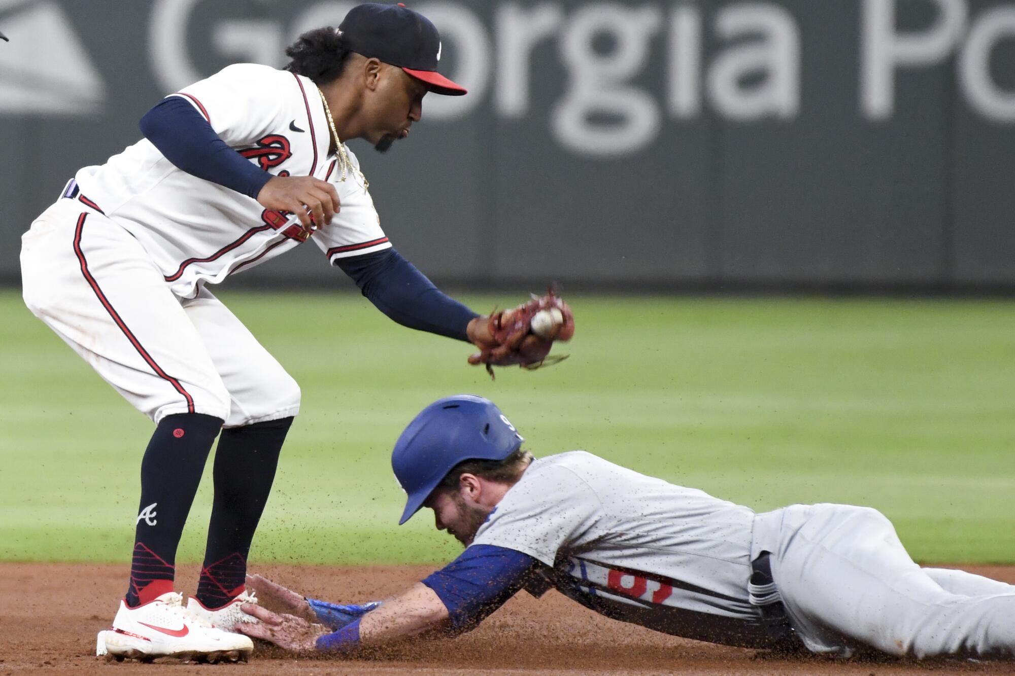 Los Angeles Dodgers' Gavin Lux, right, steals second base ahead of the tag by Atlanta Braves second baseman Ozzie Albies