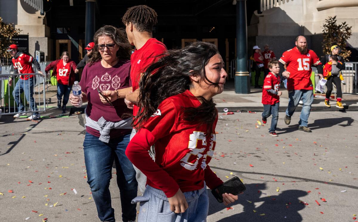 Families in red Chiefs shirts fleeing from a parade route