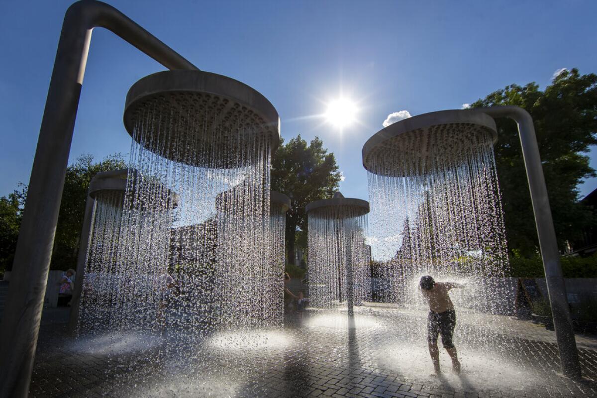 Un niño se refresca en una fuente pública en Vilna, Lituania,