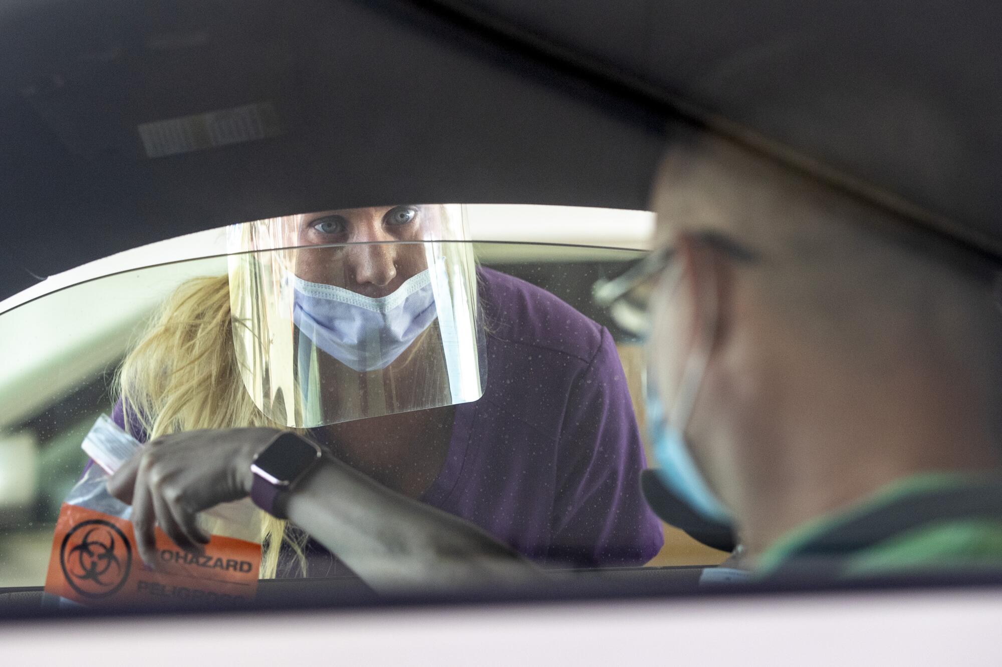 Nurse Debbie Davidson takes a test sample at the COVID-19 testing site at the Kern County Fairgrounds on Thursday.