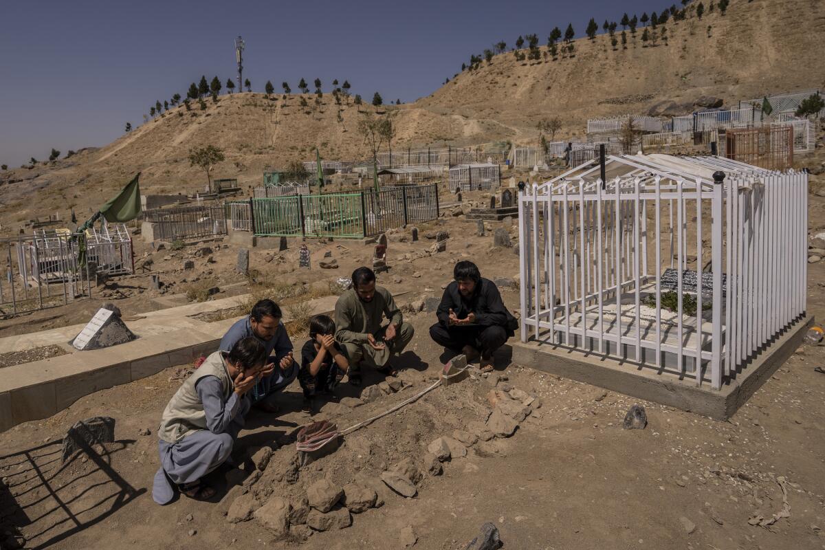  la familia Ahmadi reza junto a las tumbas de sus 10 familiares, incluidos siete niños