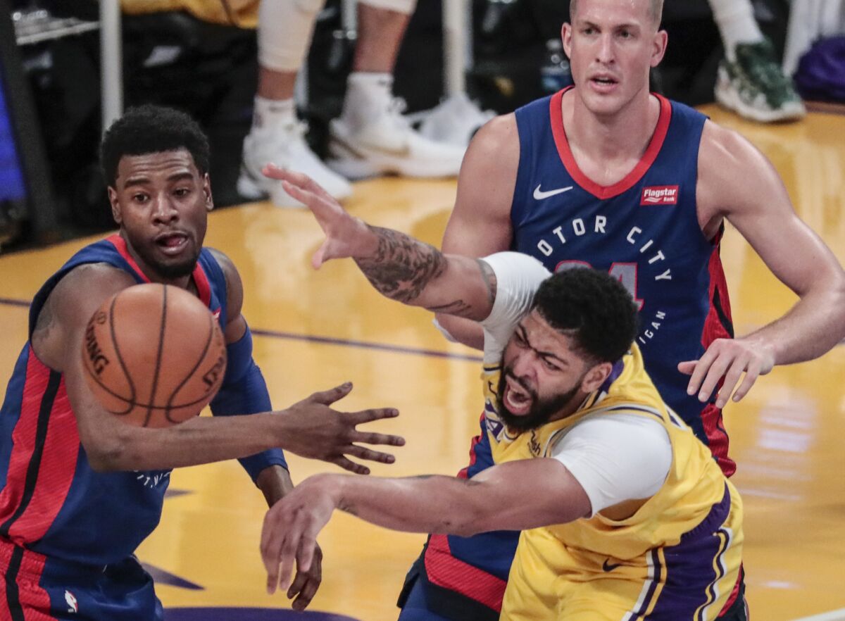 Lakers forward Anthony Davis struggles to pass the ball in front of Pistons guard Josh Jackson and center Mason Plumlee.
