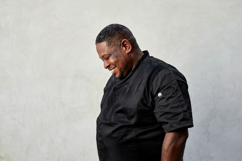 Portrait of Chef Keith Corbin against a gray wall.