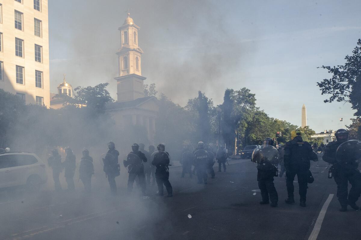 Police use tear gas to force protesters away from St. John's Church near the White House on June 1 for a Trump photo op.