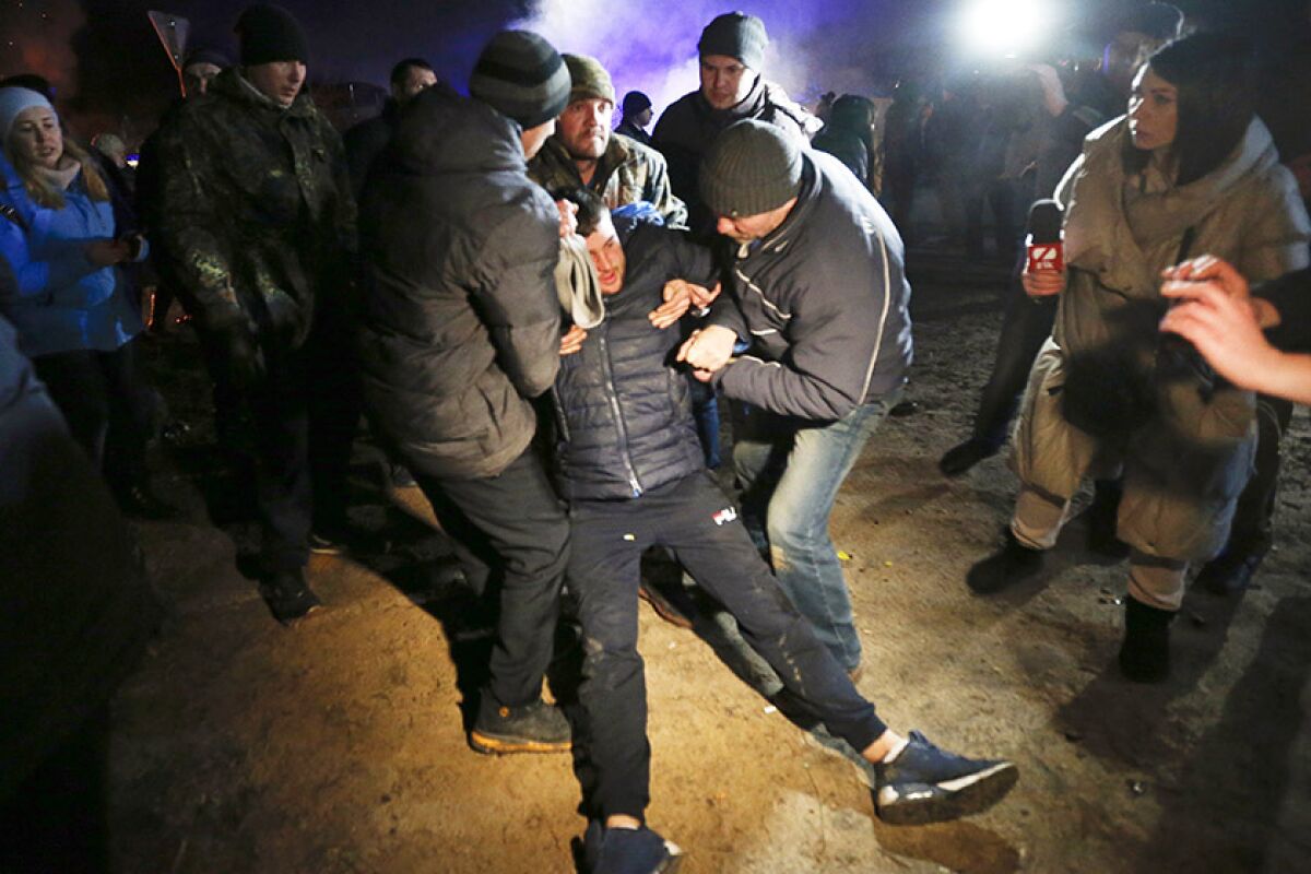 A man is assisted by fellow protesters after clashes with riot police on Thursday.