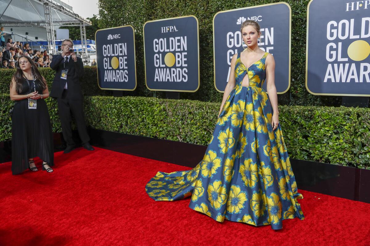 Taylor Swift arriving at the 77th Golden Globe Awards red carpet in a yellow and blue flower covered gown