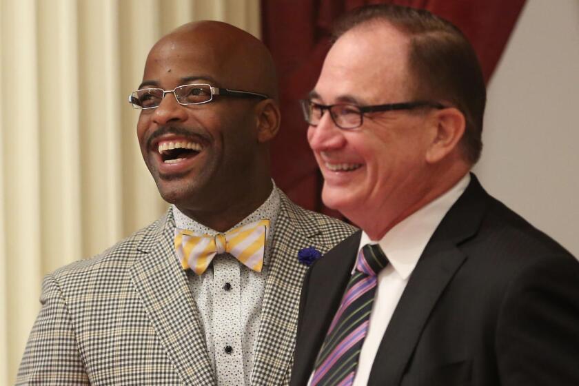 Assemblyman Isadore Hall (D-Compton), left, and Senate Minority Leader Robert Huff (R-Diamond Bar) smile as Hall's measure seeking to ban California from selling or displaying items with the Confederate flag was approved by the Senate on Monday.