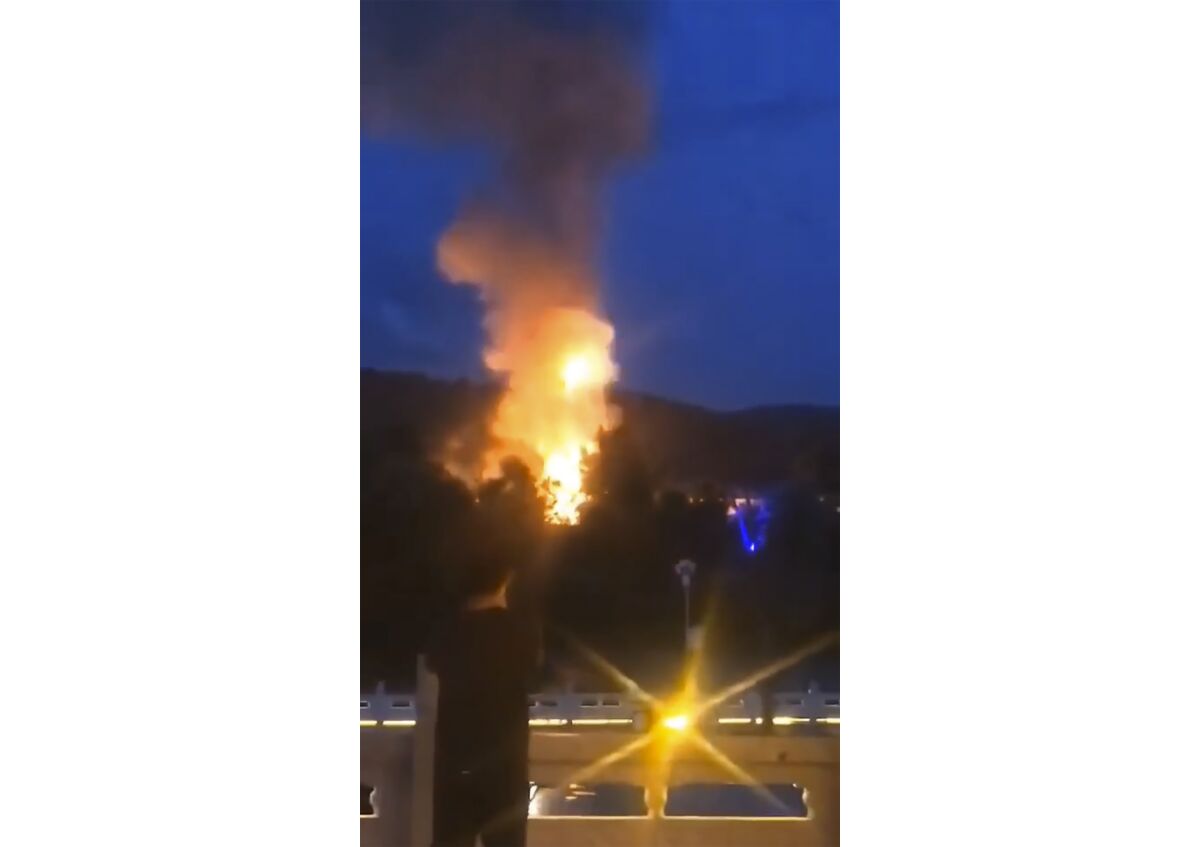 In this image taken from an Aug. 3, 2020, video provided by Wang Bo via AP Video, plumes of smoke and fire can be seen rising from Hyesan, a North Korean city, seen across the border from a park in the Chinese border town of Changbai in northeastern China's Jilin Province. There have been no official words from both North Korea and China about what happened on the North's Hyesan city on Monday. But South Korean media and outside monitoring groups reported that chain gas explosions in Hyesan's residential area left dozens of people dead or injured. (Wang Bo via AP Video)