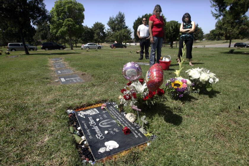 Family members, left to right, father Rafael Sierra, mother Imelda Sierra, and sister Fabiola Saavedra commemorate the death of Brenda Sierra at her grave site in the Resurrection Cemetery in Monterey Park on July 15 2009.