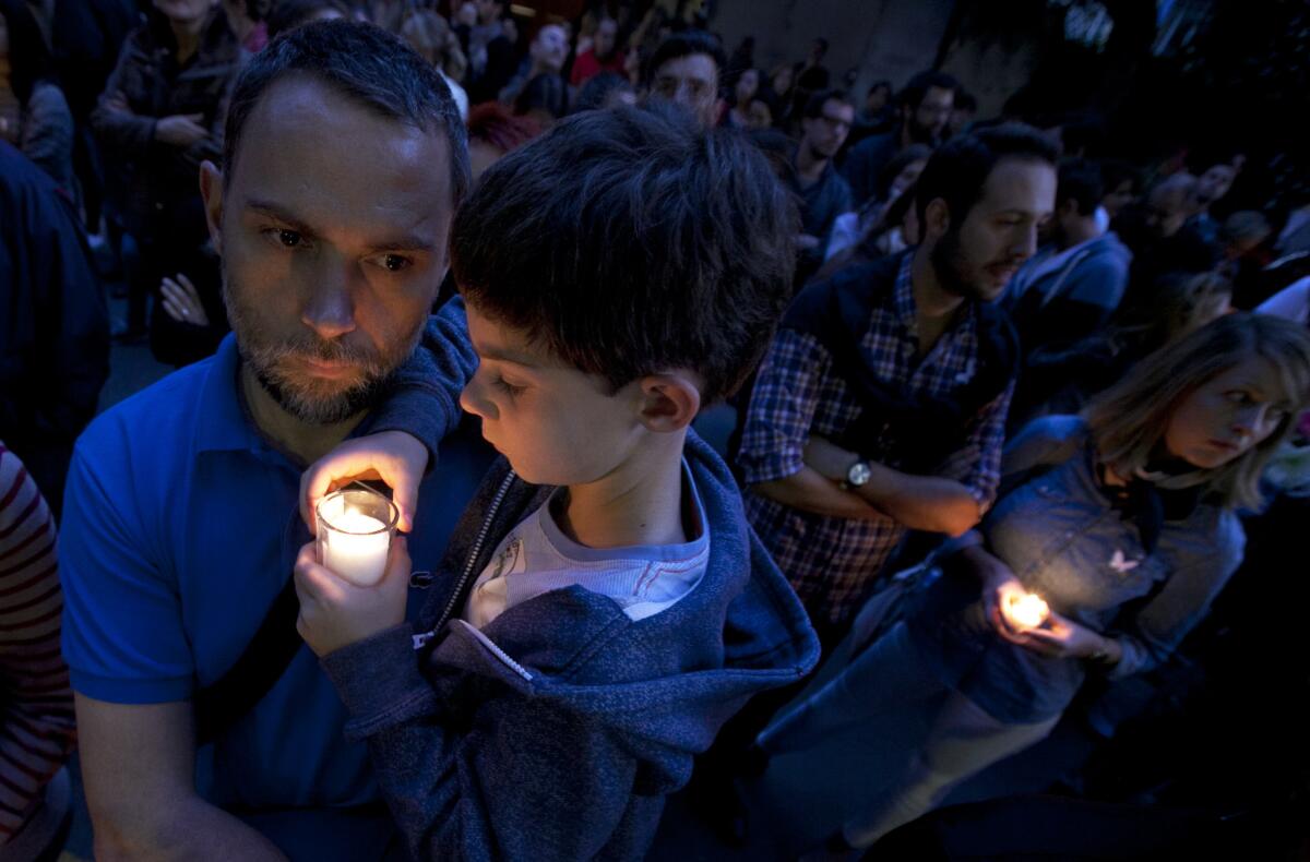 En esta imagen de archivo, un hombre sostiene a un niño en brazos ante la embajada francesa en Ciudad de México durante una vigilia por las víctimas de los atentados terroristas en París.