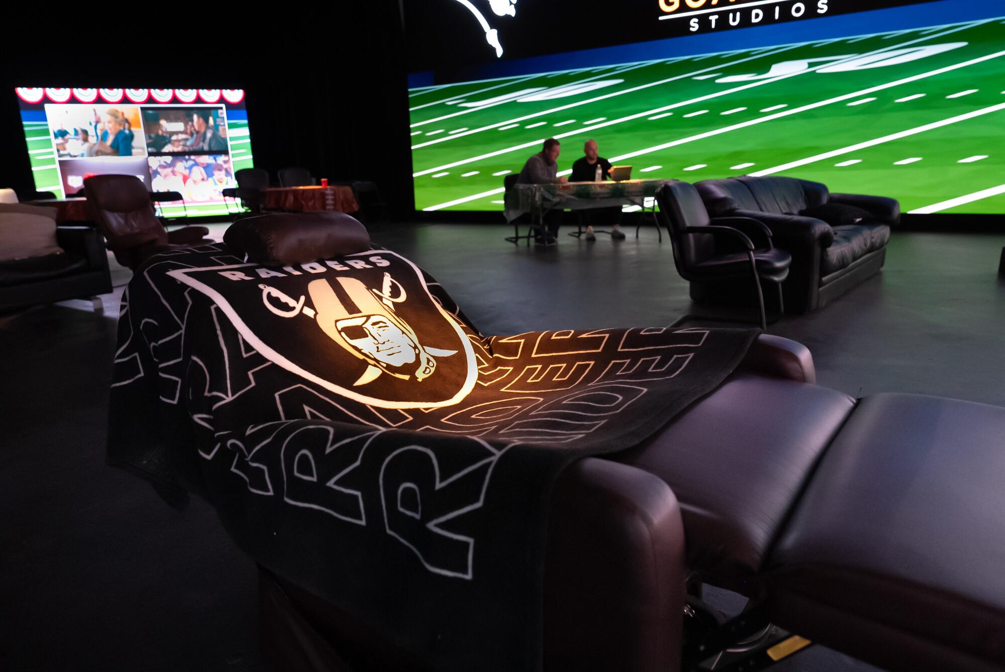 A spotlight on a Raiders blanket on an empty recliner.