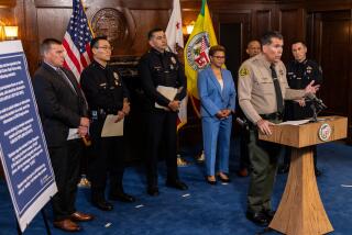 LOS ANGELES, CA - AUGUST 17: LA County Sheriff Robert Luna, flanked by Deputy Chief LAPD Kris Pitcher, left, task force in-charge, Chief LAPD Dominic Choi, Assistant Chief of LAPD Alfred Labrata, L.A. Mayor Karen Bass, LA Police Commissioner Dr. Erroll Southers and Glendale Police Chief Manuel Cid, talks about forming a task force to investigate, apprehend and prosecute suspects who have committed retail thefts smash-and-grabs in recent weeks, at a press conference held at City Hall in Los Angeles, CA. (Irfan Khan / Los Angeles Times)