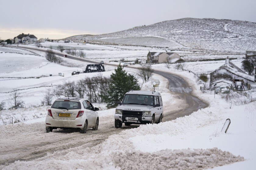 Vehicles travel tentatively on the snow-covered A53 close to Buxton in Derbyshire, amid freezing conditions in the aftermath of Storm Arwen, England, Sunday, Nov. 28, 2021. (Jacob King/PA via AP)