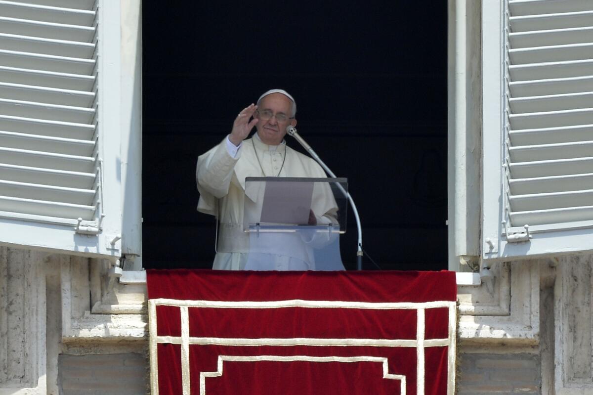 Pope Francis addresses the crowd from the window of his apartments during the Angelus prayer at St. Peter's Square on July 20.