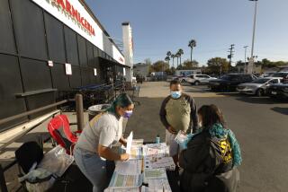 LOS ANGELES, CALIFORNIA-OCT. 24, 2022-Vivian Ramirez, left, and Maria Mejia, right, Soledad Enrichment Action community health workers, distribute COVID-19 related resources at a supermarket on Whittier Blvd. in Los Angeles on Oct. 24, 2022. (Carolyn Cole / Los Angeles Times)
