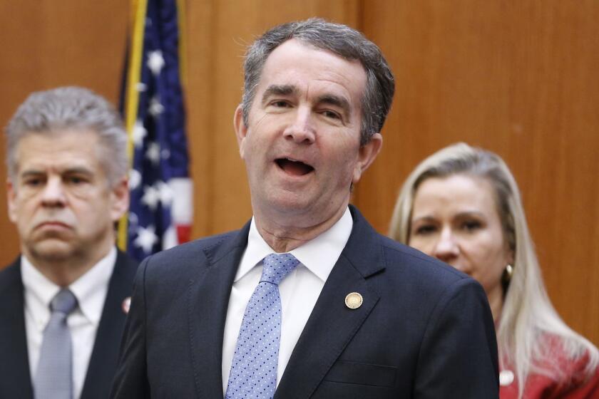 Virginia Gov. Ralph Northam , front, speaks as House speaker, Kirk Cox, left, and State Sen. Amanda Chase, R-Chesterfield, right, during a press conference relating to a bipartisan agreement on a coal ash bill at the Capitol in Richmond, Va., Thursday, Jan. 24, 2019. (AP Photo/Steve Helber)