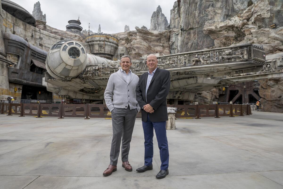 Bob Iger and Bob Chapek of Walt Disney Co. stand in front of the Millennium Falcon ride.