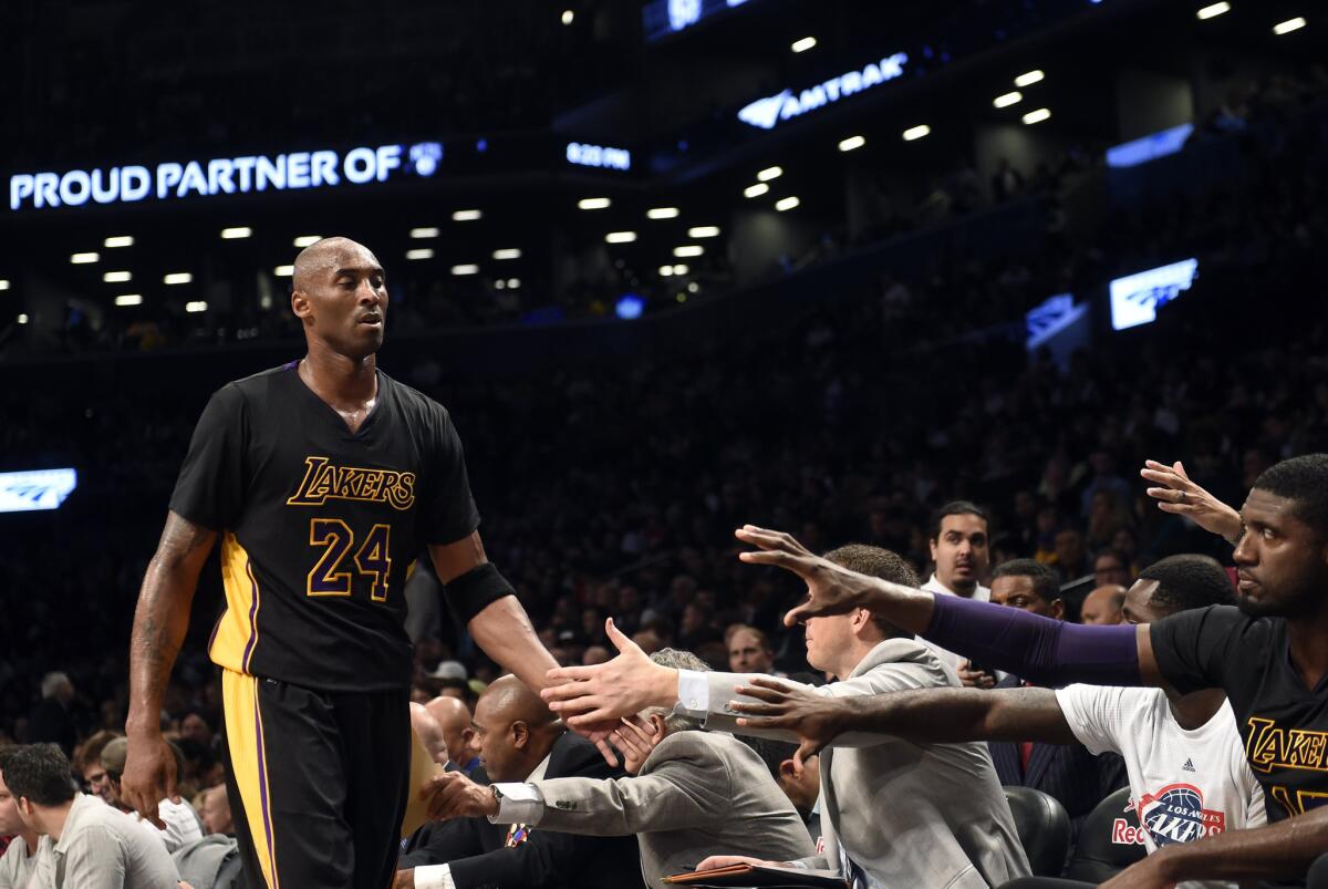 Lakers forward Kobe Bryant walks to the end of the bench after coming out of the game in the first half against the Nets.