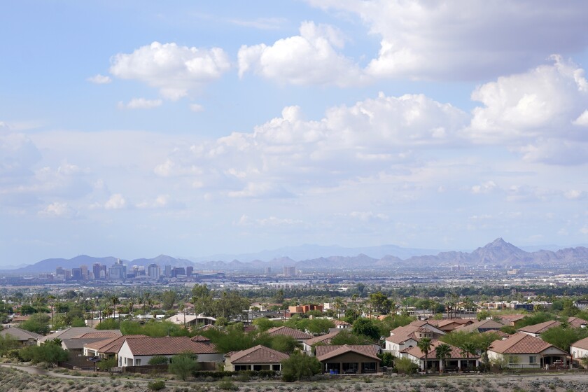 FILE -With the downtown skyline in the background, expansive urban sprawl continues to grow, Thursday, Aug. 12, 2021, in Phoenix. A county in the heart of metro Phoenix and several counties in Texas' fastest-growing metro areas had the biggest jumps in the numbers of white, Black, Asian and Hispanic residents last year, while California's Inland Empire also had among the biggest booms in Hispanic residents, according to new estimates released Thursday, June 30, 2022 (AP Photo/Ross D. Franklin, File)