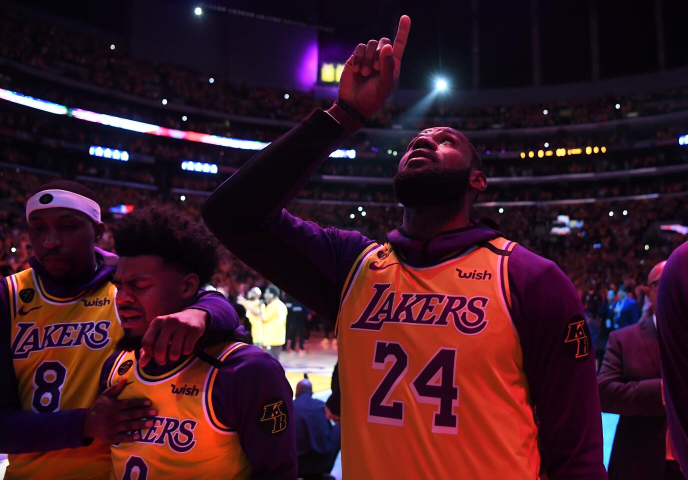 LeBron James points to the sky as Kentavious Caldwell-Pope comforts Quinn Cook during a ceremony honoring the life of Kobe Bryant at Staples Center on Jan. 31, 2020.