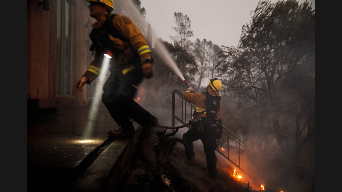Contra Costa firefighters work to put out flames burning inside a home along Highway 29 north of Calistoga on Oct. 12.