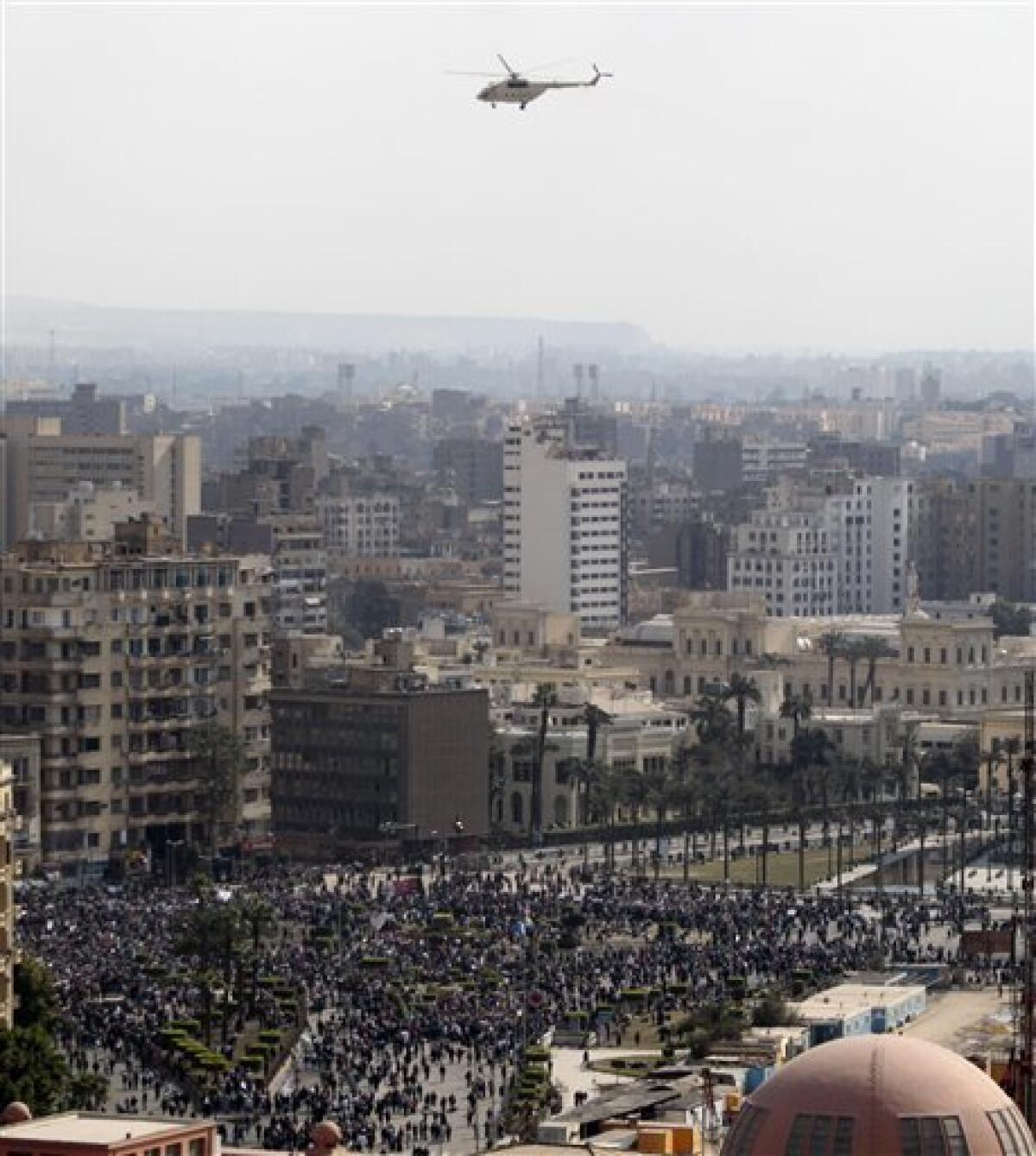 A mililtary helicopter flies protestors gathered in Tahrir, or Liberation Square, in Cairo, Egypt, Monday Jan. 31, 2011. A coalition of opposition groups called for a million people to take to Cairo's streets Tuesday to demand the removal of President Hosni Mubarak. (AP Photo/Lefteris Pitarakis)