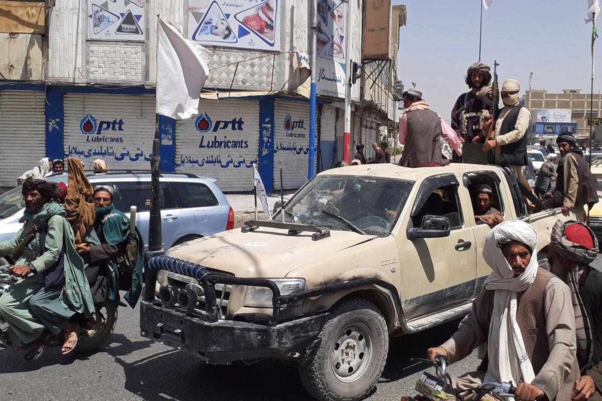A pickup truck carrying fighters moves through traffic in Kandahar.
