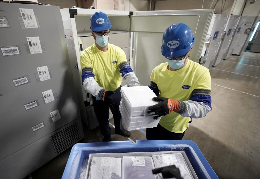 FILE - Boxes containing the Pfizer COVID-19 vaccine are prepared to be shipped at the Pfizer Global Supply Kalamazoo manufacturing plant in Portage, Mich., Dec. 13, 2020. The nation’s COVID-19 death toll stands at around 800,000 as the anniversary of the U.S. vaccine rollout arrives. A year ago it stood at 300,000. What might have been a time to celebrate a scientific achievement is fraught with discord and mourning. (AP Photo/Morry Gash, Pool, File)