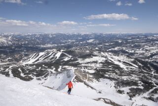 A skier descends Lone Mountain at Big Sky Resort in Montana, with a view of some of the property's other runs below.