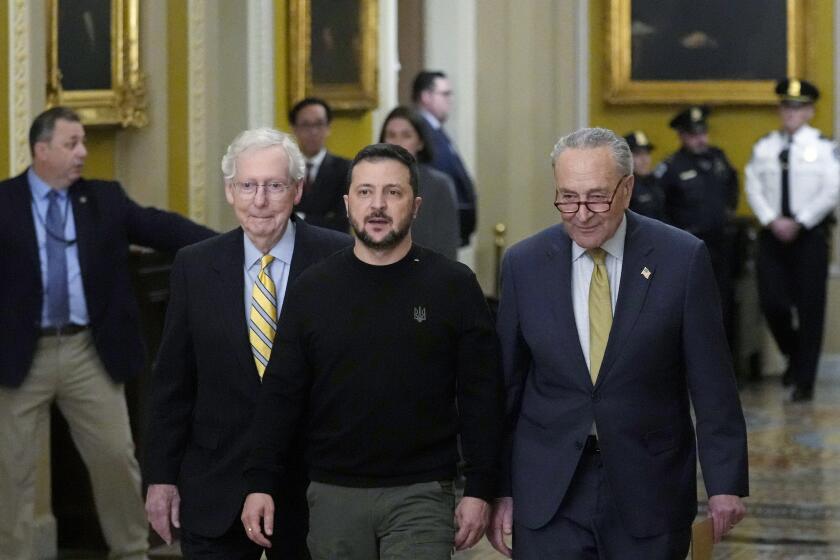 Ukrainian President Volodymyr Zelenskyy, center, walks with Senate Minority Leader Mitch McConnell of Ky., left, and Senate Majority Leader Chuck Schumer of N.Y., right, during a visit to Capitol Hill in Washington, Tuesday, Dec. 12, 2023. (AP Photo/Susan Walsh)