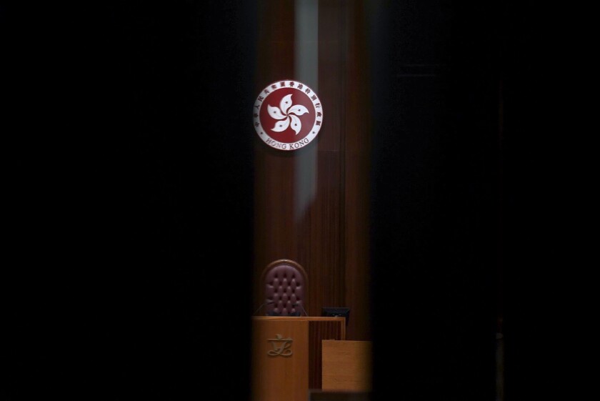 The logo of Hong Kong Special Administrative Region is seen through the glass of a closed door after the first and second meeting of "Improving Electoral System (Consolidated Amendments) Bill 2021" finished at the Legislative Council in Hong Kong Wednesday, April 14, 2021. Hong Kong’s electoral reform bill was introduced in the city’s legislature on Wednesday, setting in motion changes that will give Beijing greater control over the process while reducing the number of directly elected representatives. (AP Photo/Vincent Yu)
