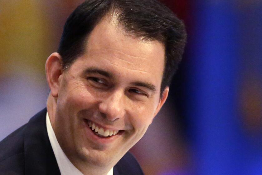 Why is this man smiling? Wisconsin Gov. Scott Walker.
