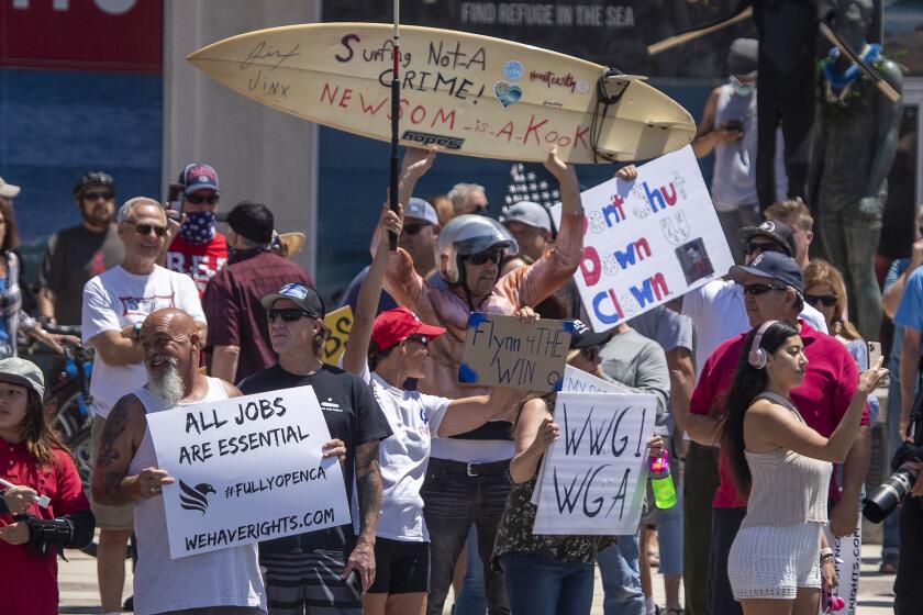 HUNTINGTON BEACH, CA -- FRIDAY, MAY 1, 2020: Thousands of protesters rally at the intersection of Main Street and Pacific Coast Highway in the``March to Open California'' to call on Gov. Newsom to relax the state's stay-at-home orders under COVID-19 in Huntington Beach, CA, on May 1, 2020. (Allen J. Schaben / Los Angeles Times)